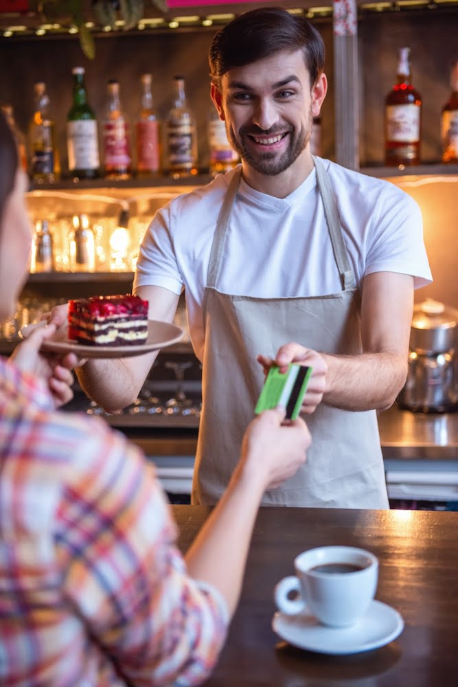 Restaurant employee signing up a customer on Ampliyo at the payment counter.